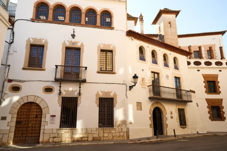 Historic building facades in the old town of Sitges, featuring balconies and traditional Catalan architecture.