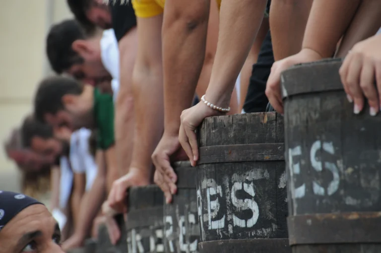 Participants treading grapes in wooden barrels during the grape treading competition at the Sitges Harvest Festival.